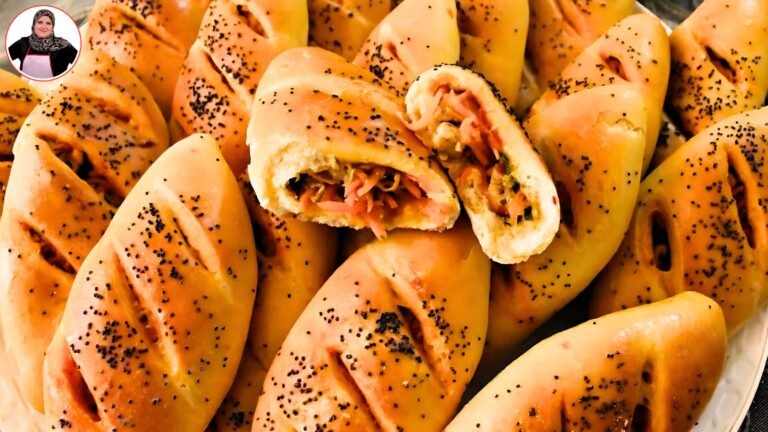 مجموعة من الفطائر المحشوة بلحم الخضروات، مغطاة بحبوب البركة ومخبوزة إلى لون ذهبي شهي، مع قطع مفتوحة تظهر الحشوة الطازجة في الداخل.