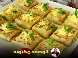 مربعات بان كيك ذهبية محشوة بالخضار واللحم، مزينة بالجبن والبقدونس على طبق أبيض.