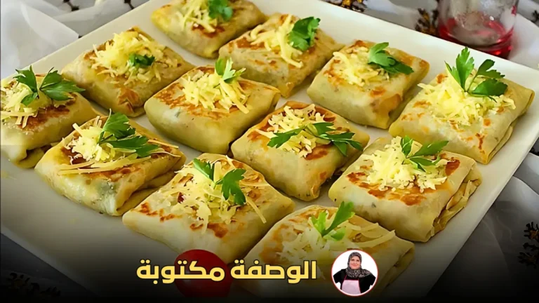 مربعات بان كيك ذهبية محشوة بالخضار واللحم، مزينة بالجبن والبقدونس على طبق أبيض.