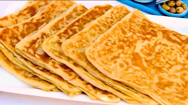 صفوف من الخبز المحشي بالجبنة مرتبة بعناية على طبق أبيض.