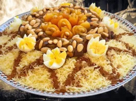 طبق مغربي من السفة المدفونة بالدجاج مزين بشرائح المشمش، اللوز المحمص، والبيض المسلوق، مع خطوط من القرفة.