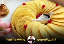 طبق بغرير مرتب بعناية مع رشة من التوت الأحمر وصوص الشوكولاتة في وعاء أبيض صغير.