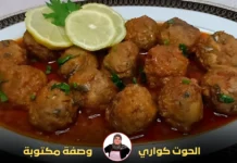 طبق من كرات السمك في صلصة طماطم غنية، مزين بشرائح الليمون والبقدونس الطازج.