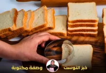 يد تستخدم أداة دائرية لتقطيع شرائح خبز التوست الأبيض.