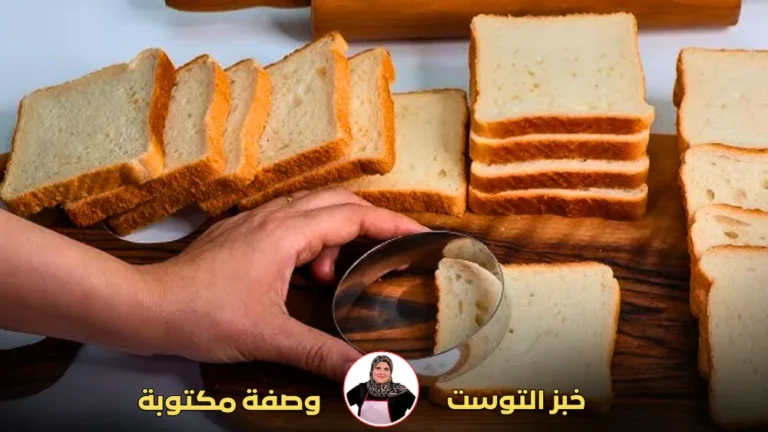 يد تستخدم أداة دائرية لتقطيع شرائح خبز التوست الأبيض.