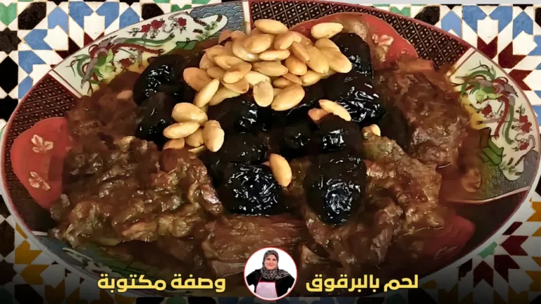 طبق مغربي تقليدي يحتوي على لحم مطهو مع البرقوق المجفف واللوز المحمص، مقدم على طبق مزخرف بزخارف شرقية.